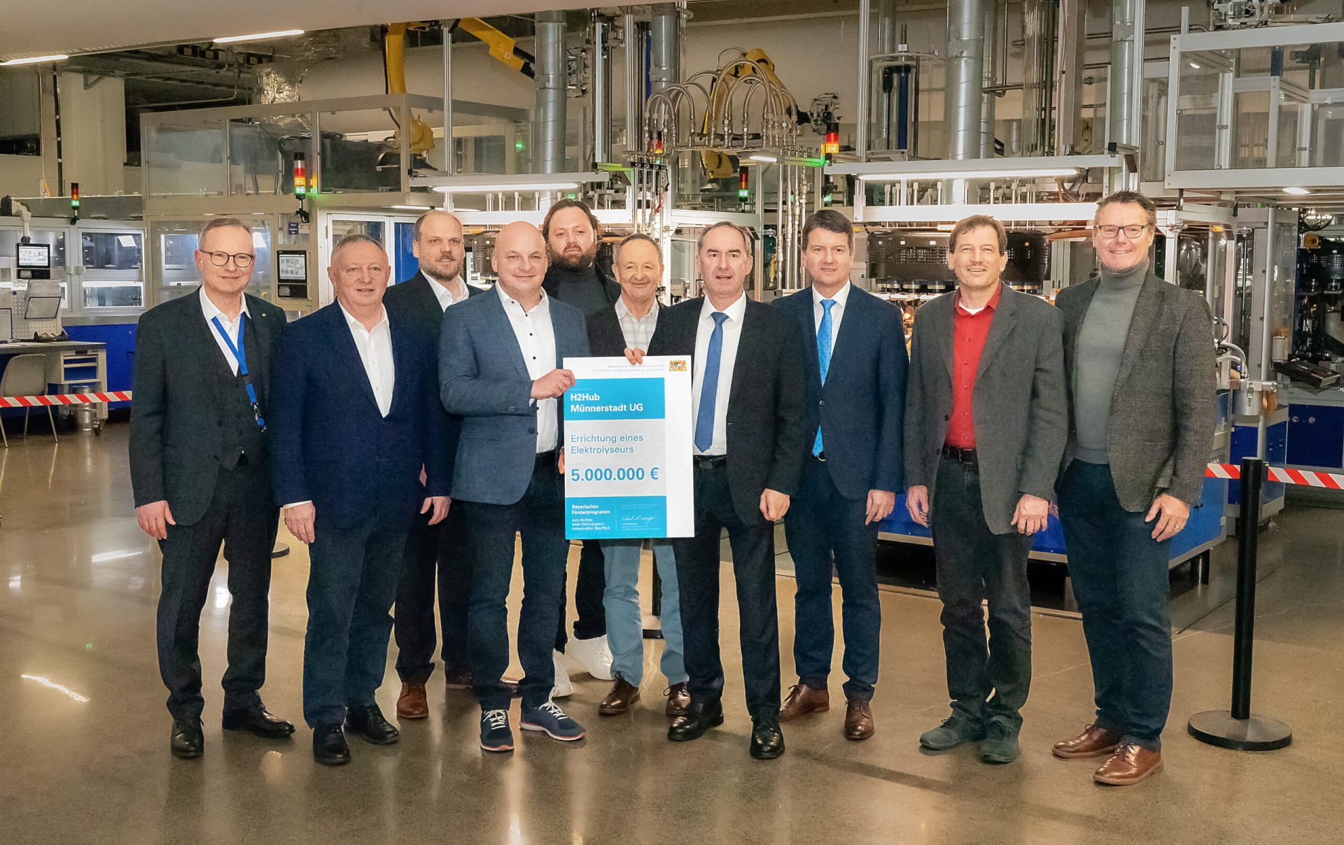 Personen auf dem Bild (v. l. n. r.) Stephan Arnold (Nipro PharmaPackaging), Thomas Bold ( Landrat), Tobias Guttroff, Michael Kastl (Bürgermeister), Tobias Guttroff (Managing Director, Guttroff Group), Joel Vogl (Infener), Norbert Schmäling (R3 RegionalEnergie), Hubert Aiwanger (Bayerischer Wirtschafts- und Energieminister), Sandro Kirchner (Staatssekretär), Alexander Stolz, Karl Heinz Wolf (AMS-Geschäftsführer).